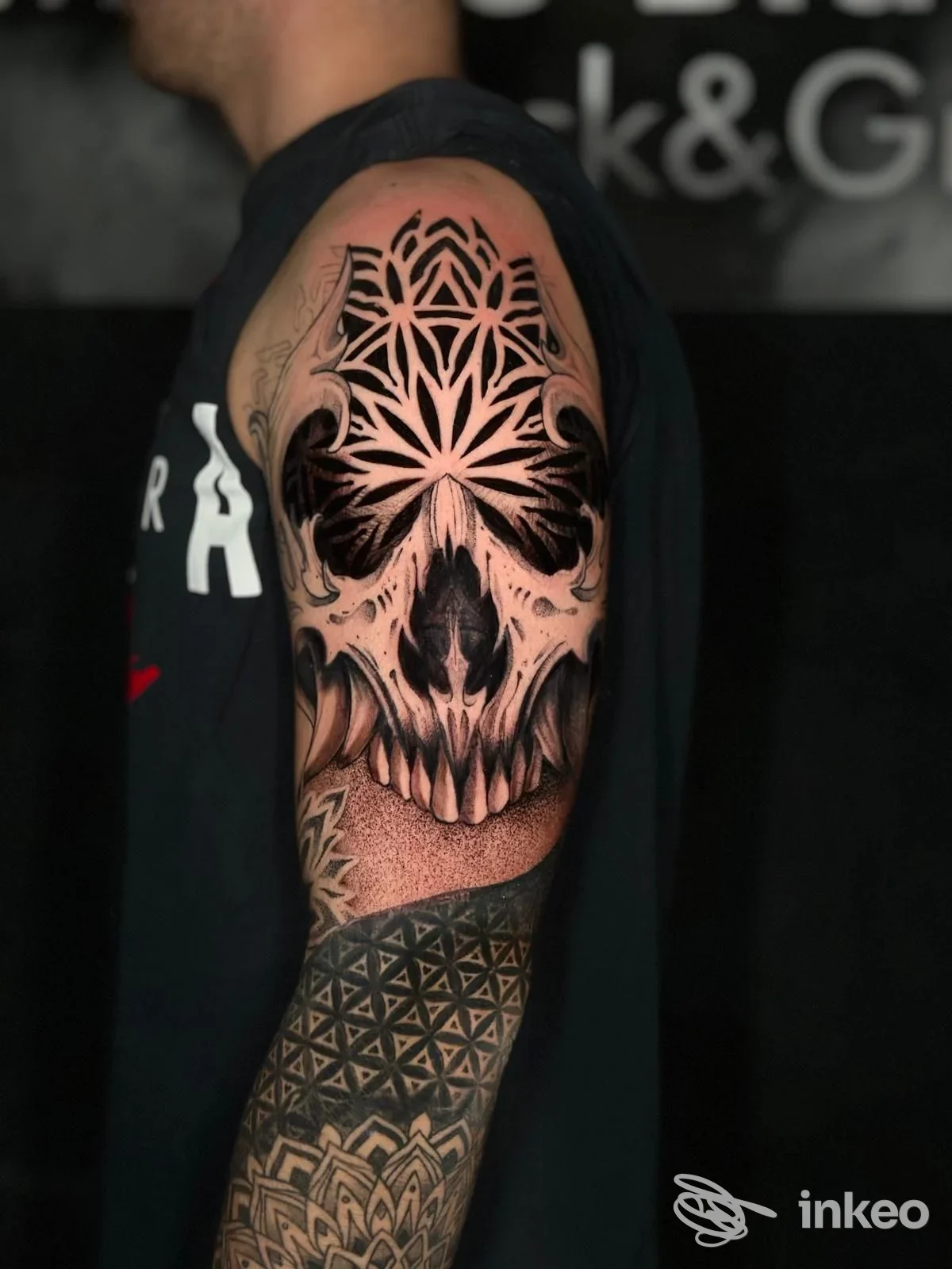 Tatuaggio sleeve con teschio e motivi geometrici sul braccio di un cliente, foto condivisa da Blackink Tattoo a Cuneo.