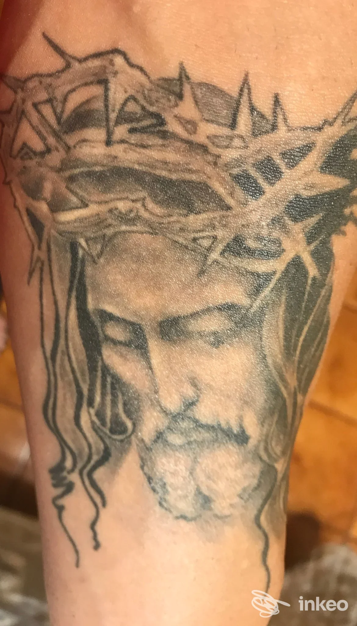 Tatuaggio realistico del volto di Cristo con corona di spine sull'avambraccio, Deep Line Tattoo, Cuneo.