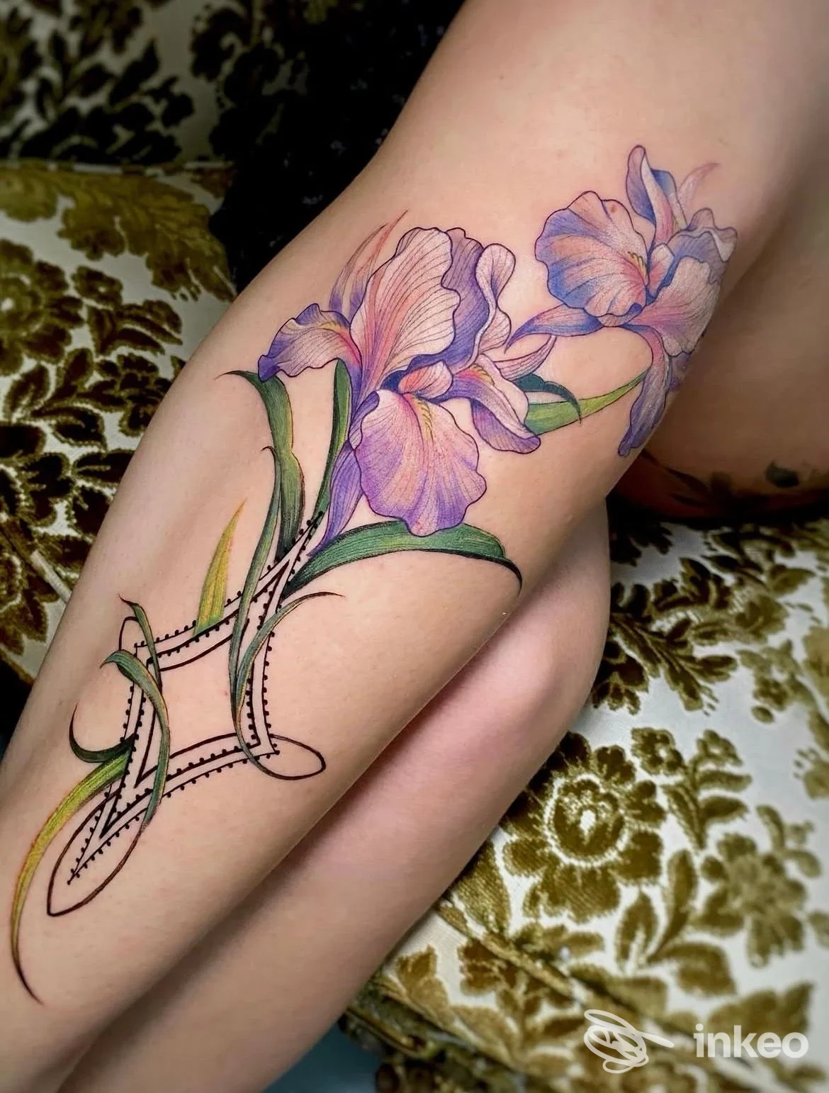 Tatuaggio floreale su coscia con iris violacei e dettagli grafici, realizzato da ETRA Tattoo Studio a Torino.