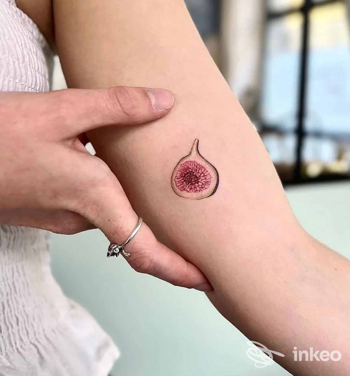 Piccolo tatuaggio a forma di fico sull'avambraccio interno, foto inviata da ETRA Tattoo Studio, Torino.