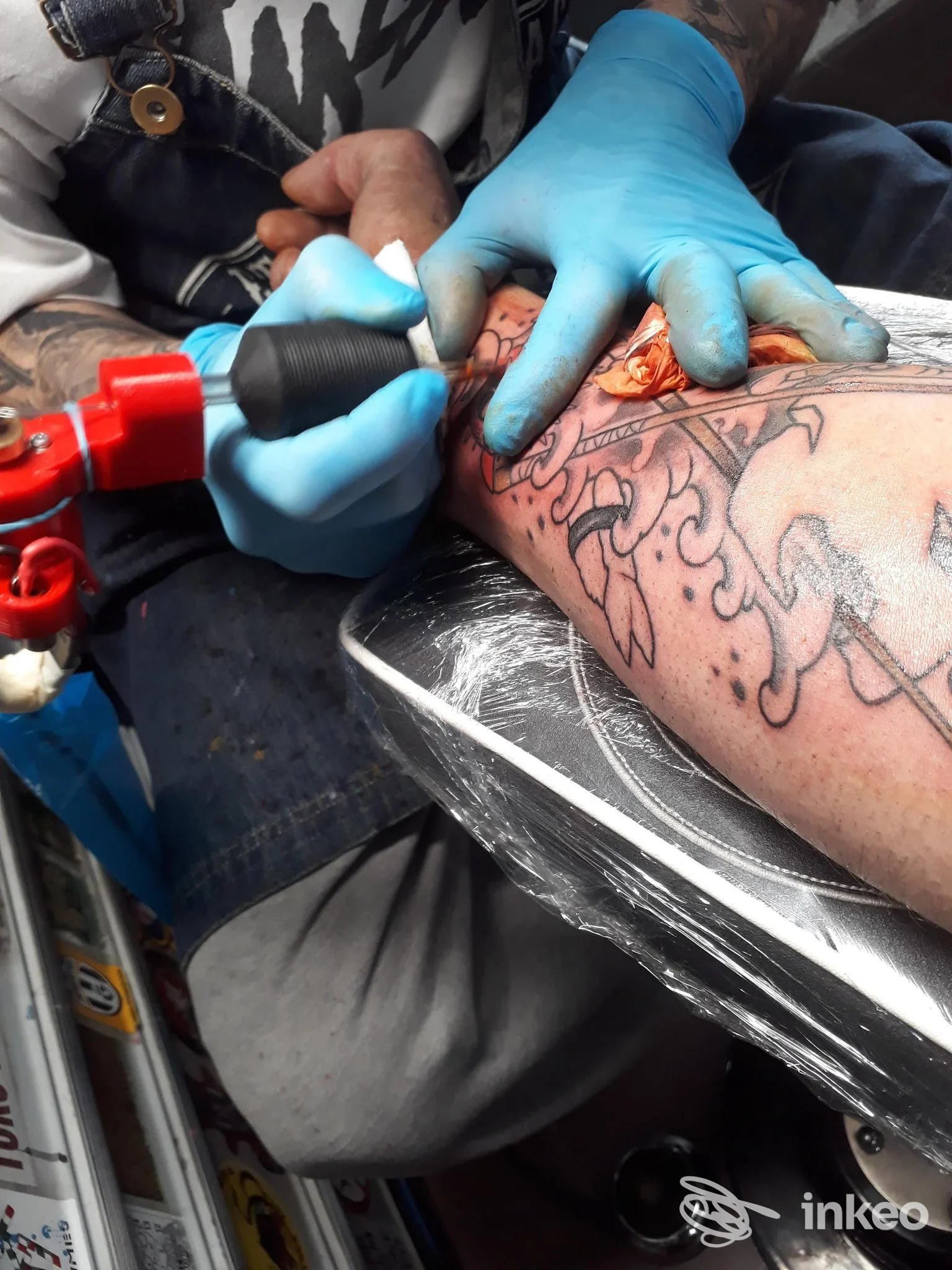 Tatuatore con guanti blu che lavora su un tatuaggio dell'avambraccio, Eterna Traccia Tattoo & Piercing, Settimo Torinese.
