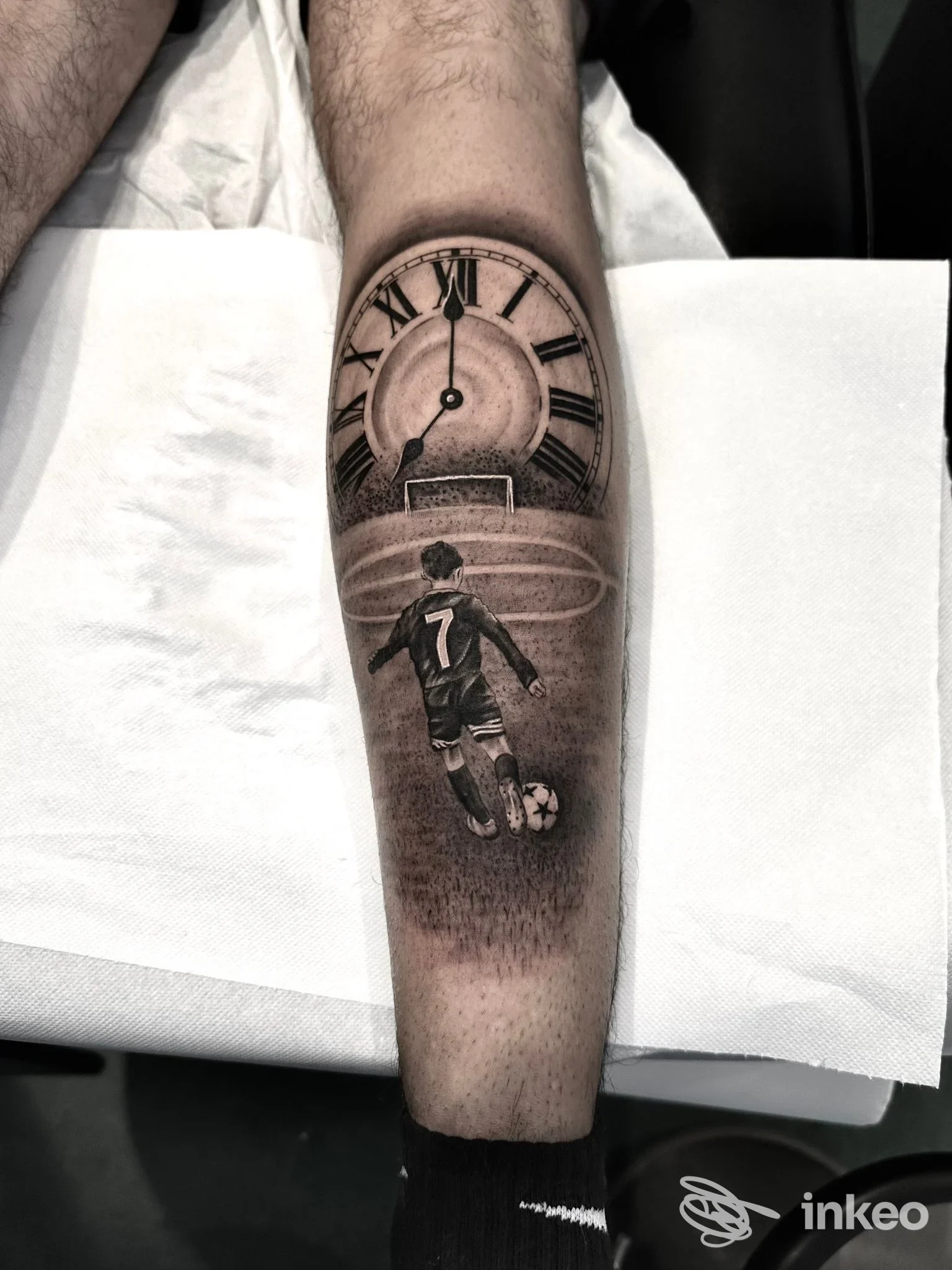 Tatuaggio black & grey sul polpaccio con quadrante d'orologio e calciatore di spalle, fotografia inviata da INKFAB tattoo studio, Torino.