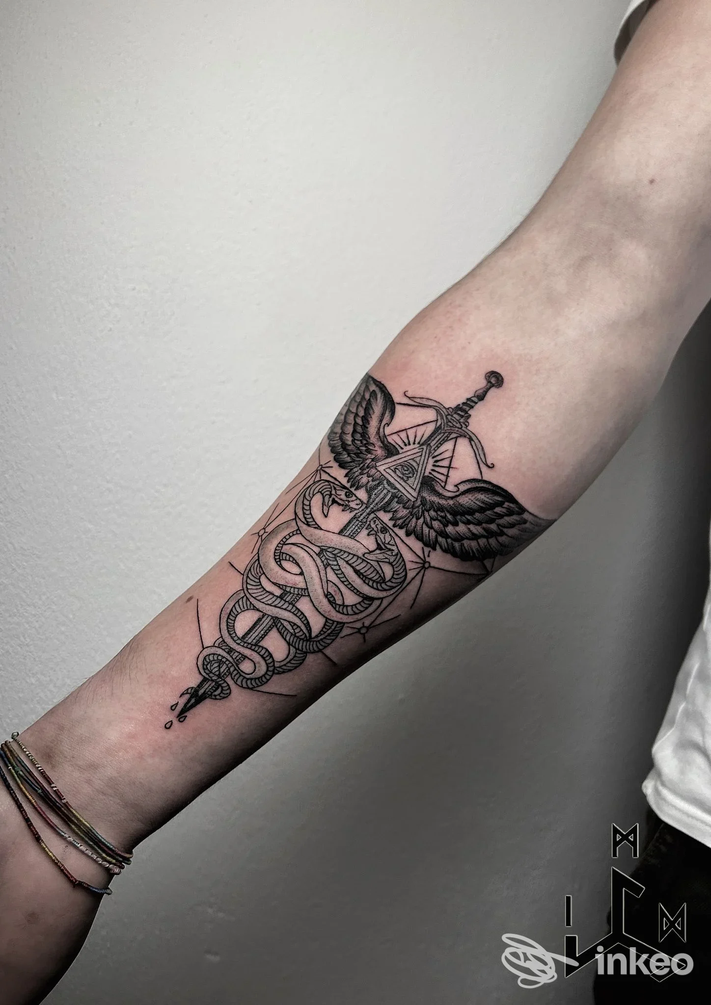 Tatuaggio su avambraccio raffigurante caduceo stilizzato, foto scattata presso In My Dungeon Tattoo Studio a Varallo Pombia.
