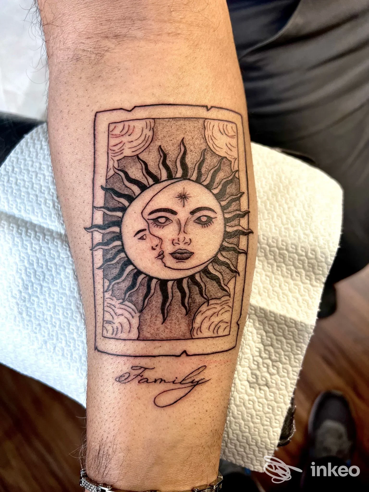 Tatuaggio sole e luna in cornice con la scritta "Family" sull'avambraccio, foto di Ink Space Tattoo Studio, Torino.