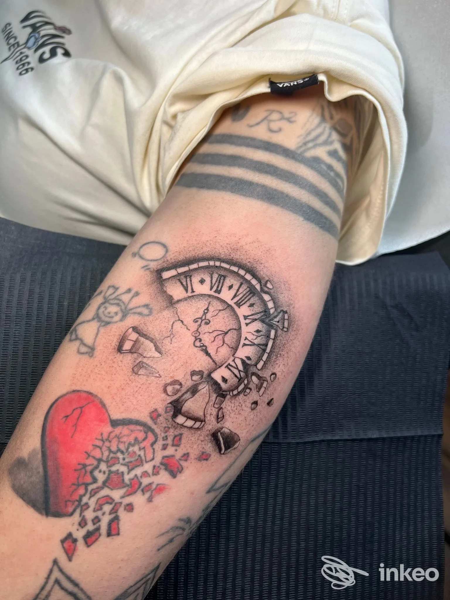 Primo piano su avambraccio con tatuaggio di orologio rotto e cuore che si sfalda, foto fornita da Ink Space Tattoo Studio, Torino.