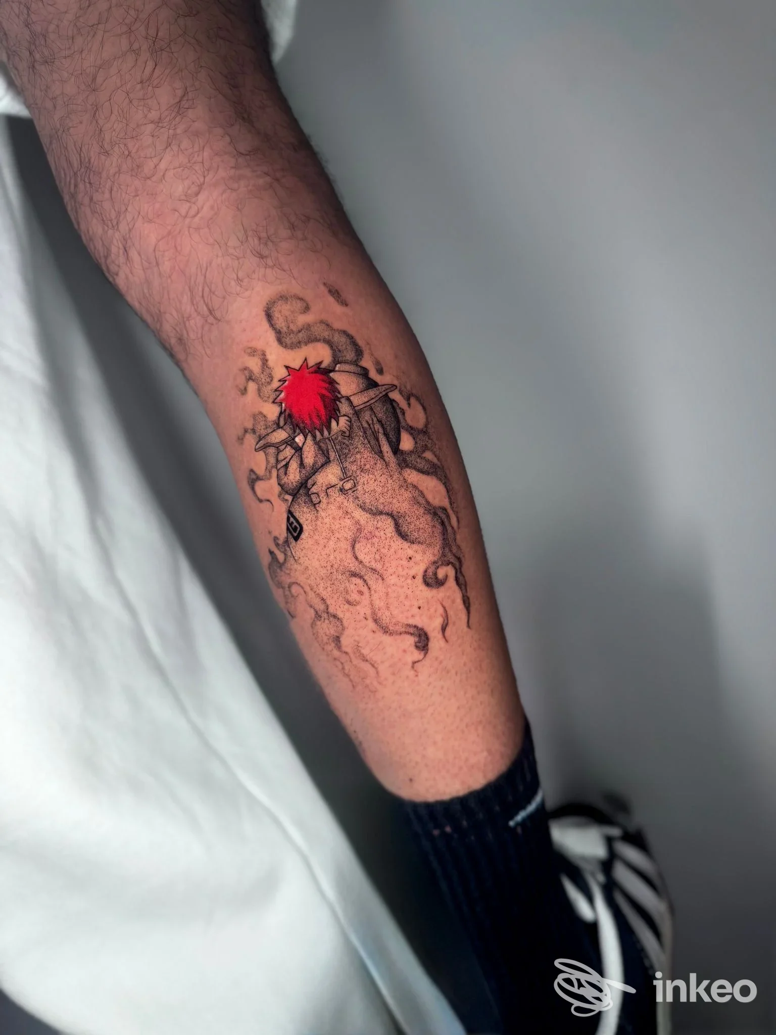 Tatuaggio sull'avambraccio con elementi neri e un dettaglio rosso, foto per Inker's Club Coworking Tattoo Studio, Torino.
