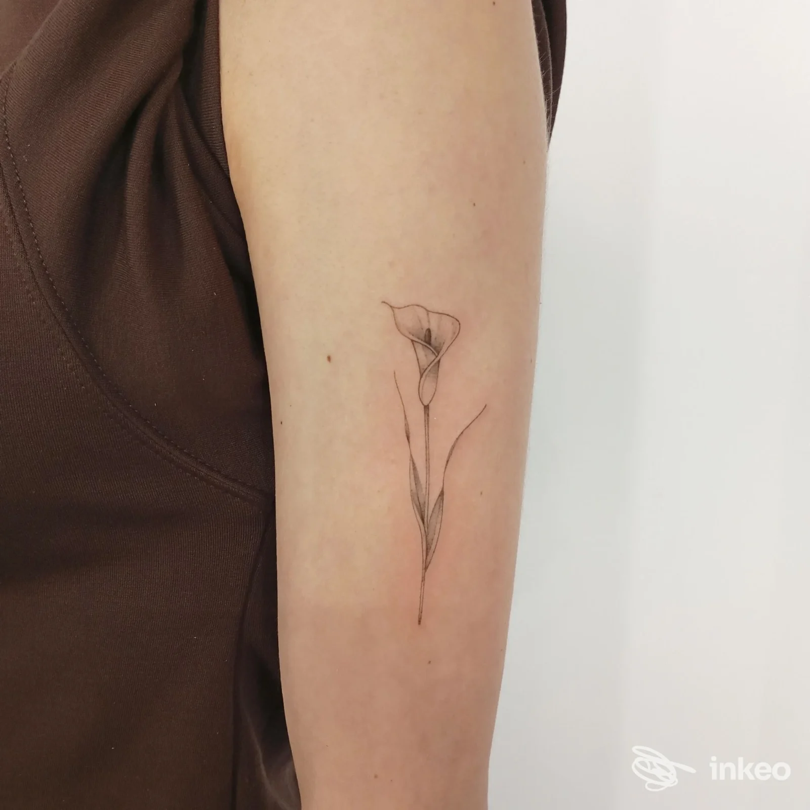 Sottile tattoo floreale monocromatico su interno braccio superiore, eseguito da Kaia tattoo a Caselle Torinese.