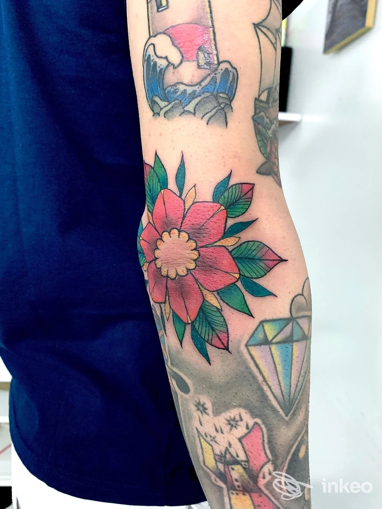 Tatuaggi su avambraccio con grande fiore colorato e diamante, foto dello stile realizzata da LOV Tattoo Studio a Caselle Torinese.