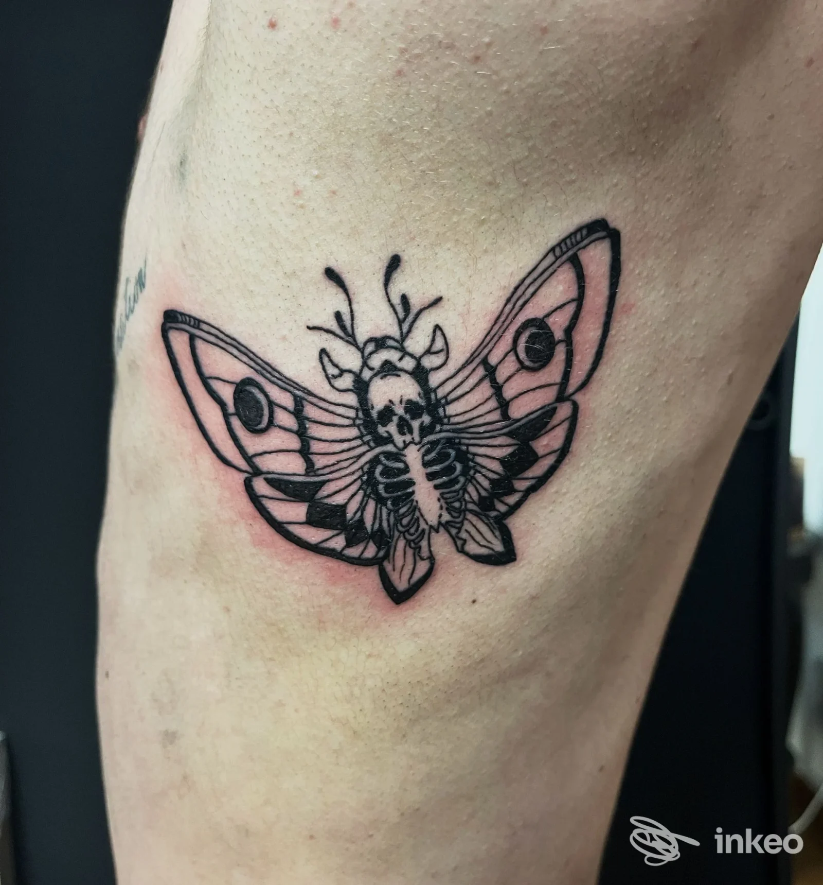 Tatuaggio a linee nere raffigurante una farfalla con elementi scheletrici sul fianco/alto braccio. Foto fornita da LaBlu Tattoo Studio, Torino.