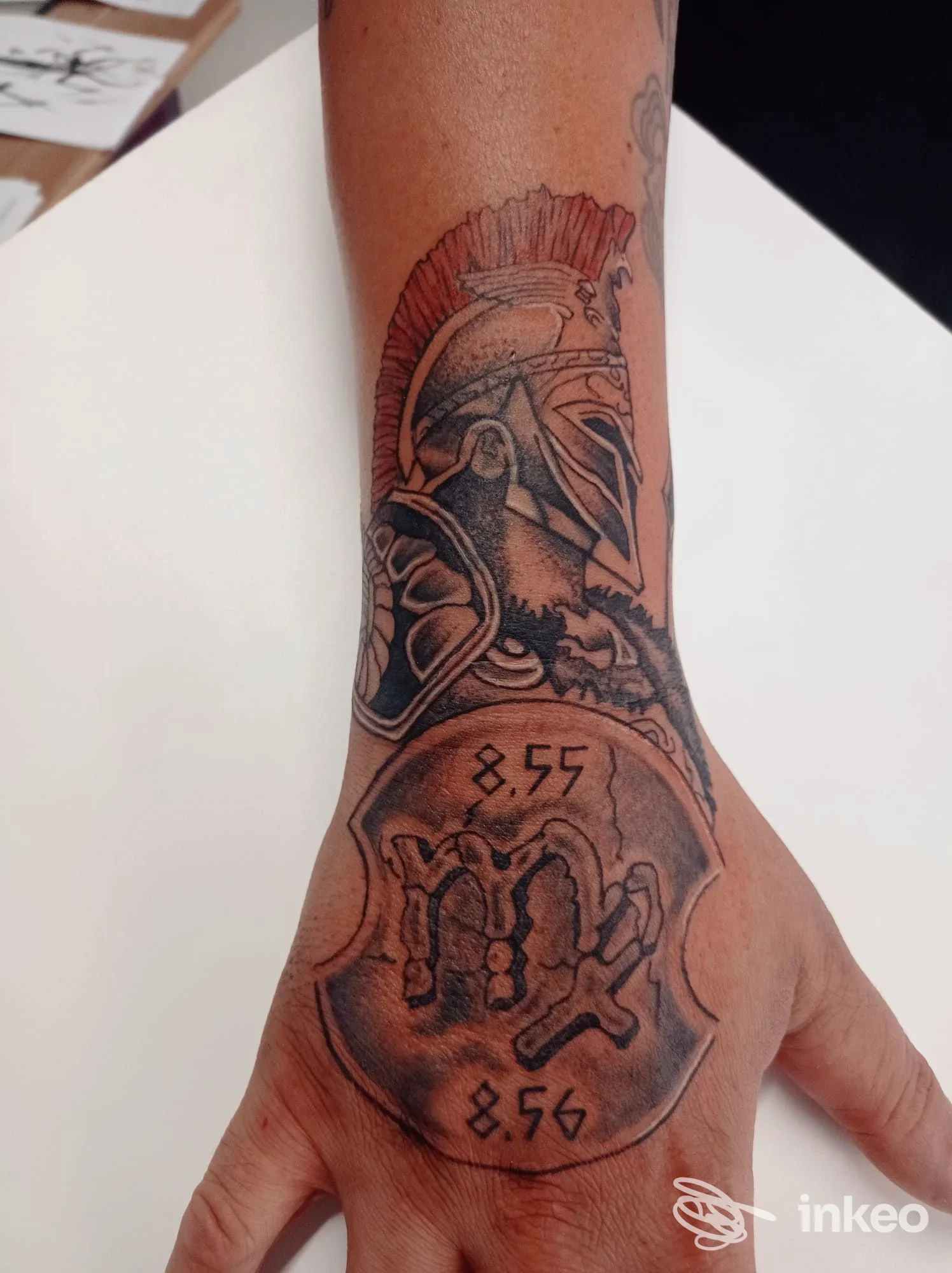 Tatuaggio su avambraccio e mano con elmo romano e scudo, fotografia dello studio Magic Tattoo Vintage a Carignano.