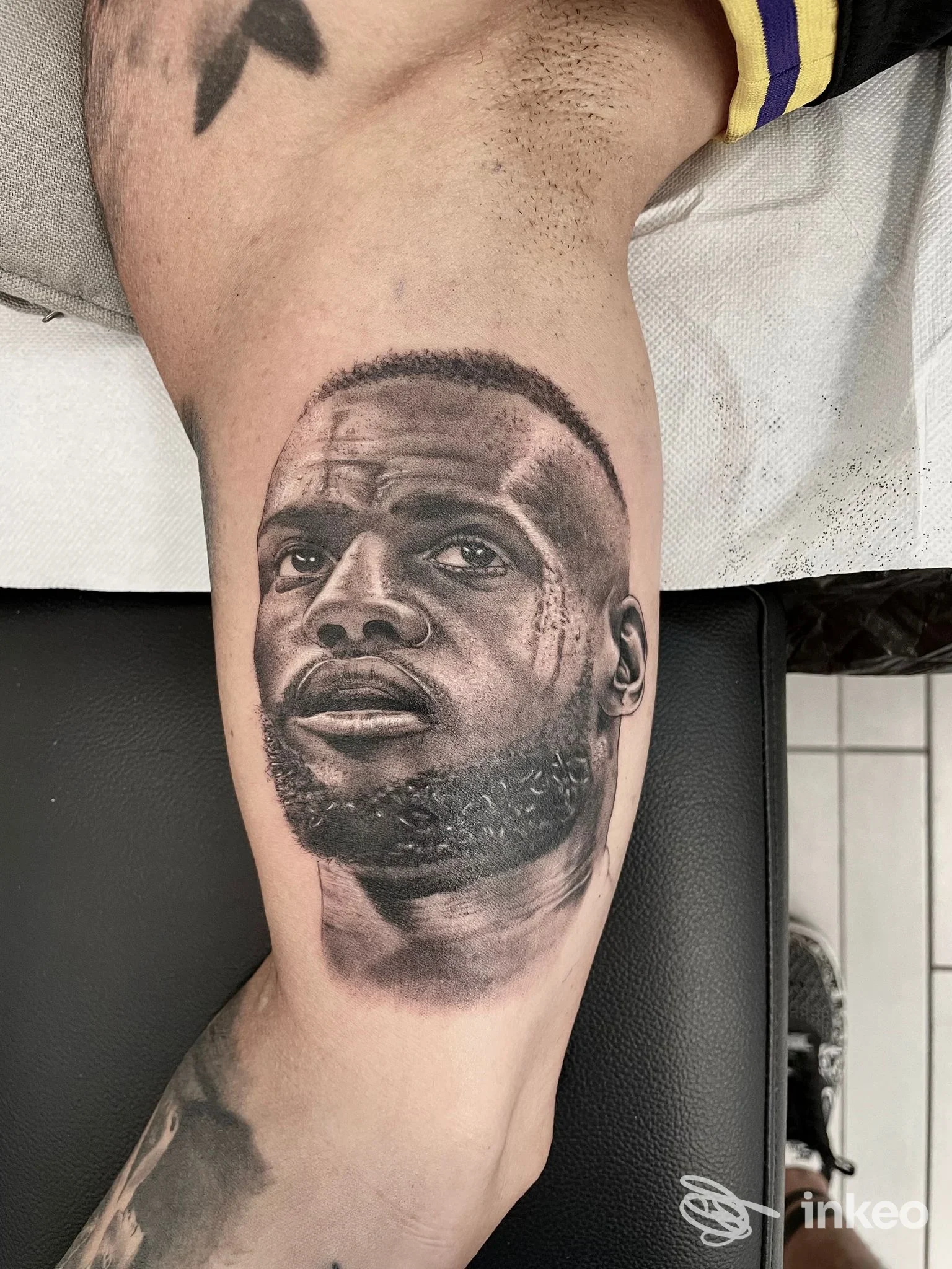 Ritratto iperrealistico in bianco e nero tatuato sull'avambraccio, realizzato da Mementovivitattoo a Intra.
