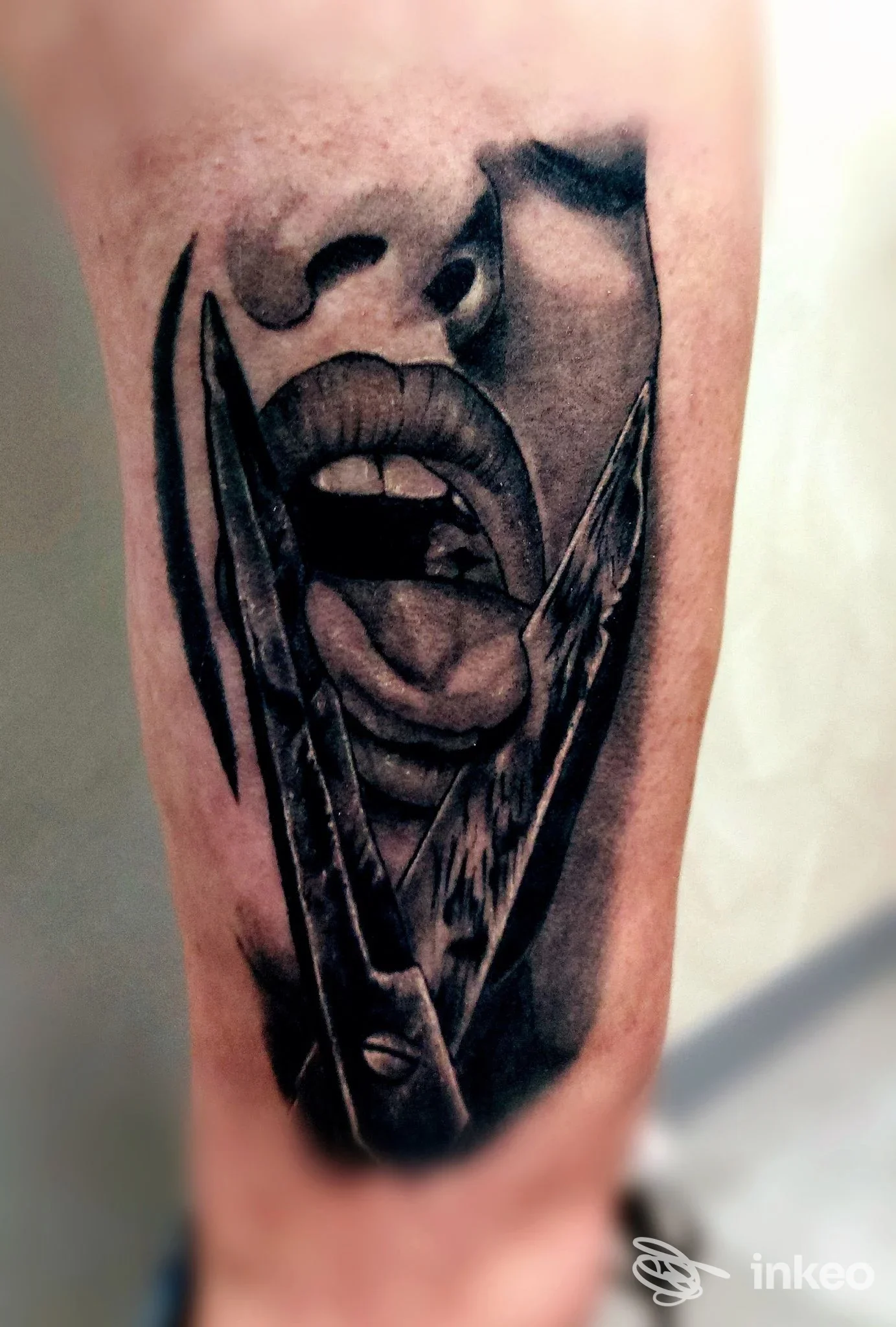 Tatuaggio realistico in bianco e nero di bocca e lingua su avambraccio, opera di Raf Tattoo a Romagnano Sesia.