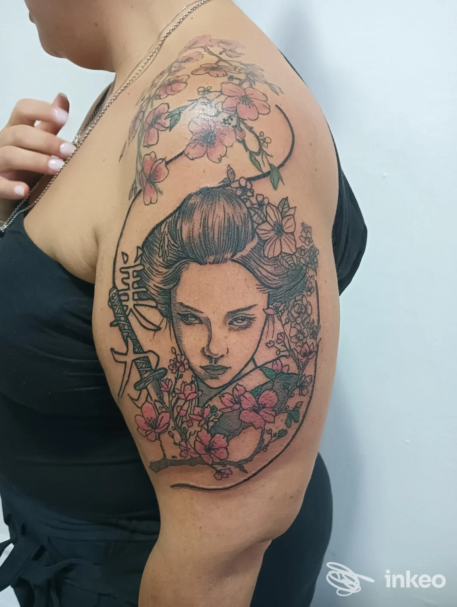 Tatuaggio grande a figura femminile con fiori sul braccio superiore, RI.O.TATTOO STUDIO, Romano Canavese.