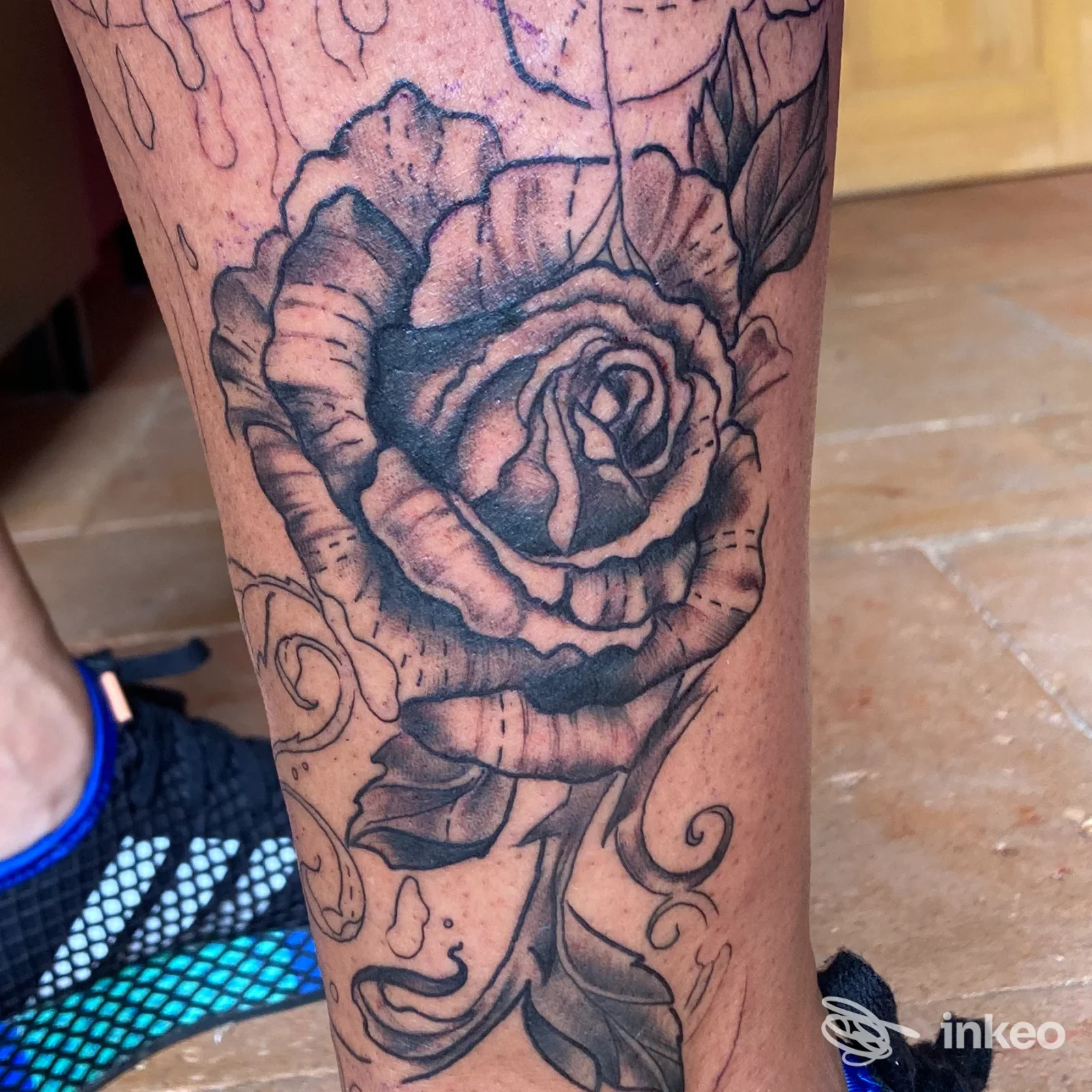 Tatuaggio a inchiostro nero di una rosa sul polpaccio, foto fornita dallo studio Redrum Tattoo a Carpignano Sesia.