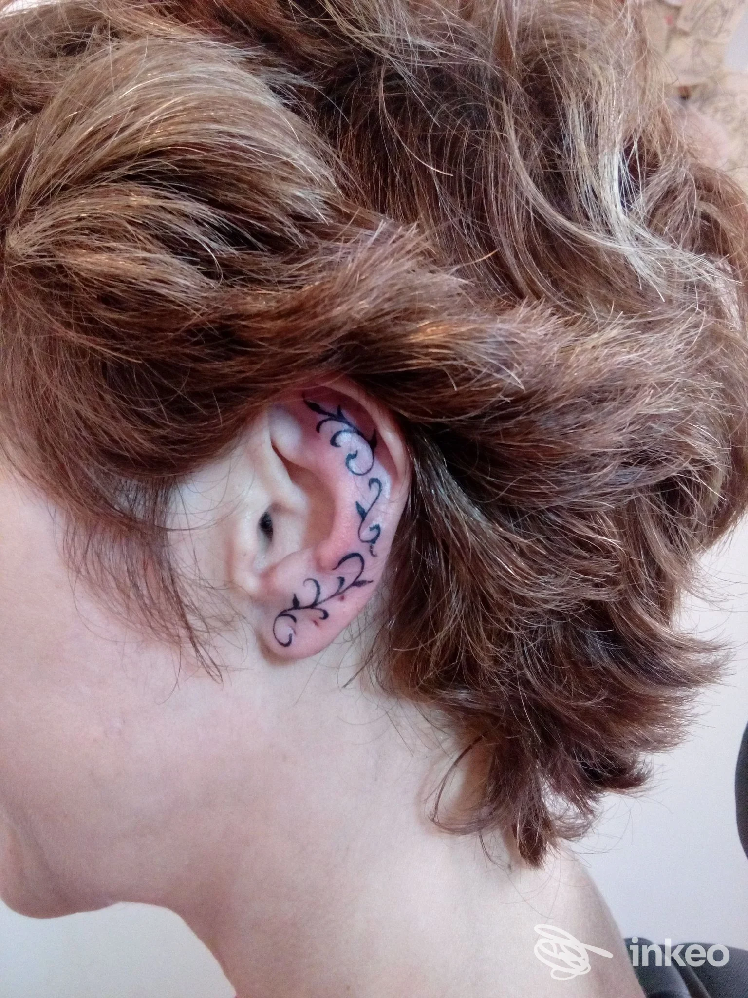 Primo piano di un orecchio tatuato con motivo ornamentale, immagine di Tattoo Communication, Acqui Terme.