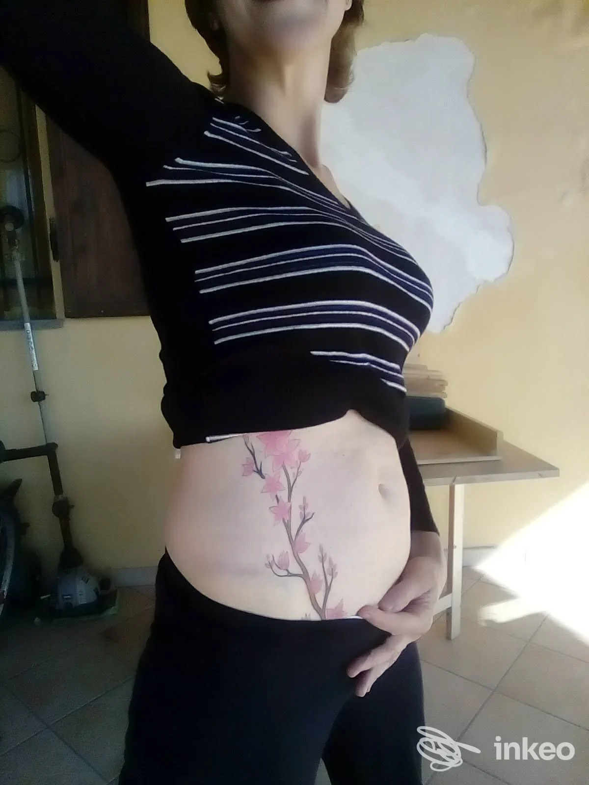 Tatuaggio floreale su addome/fianco destro mostrato su una cliente, immagine fornita da Tattoo Communication, Acqui Terme.