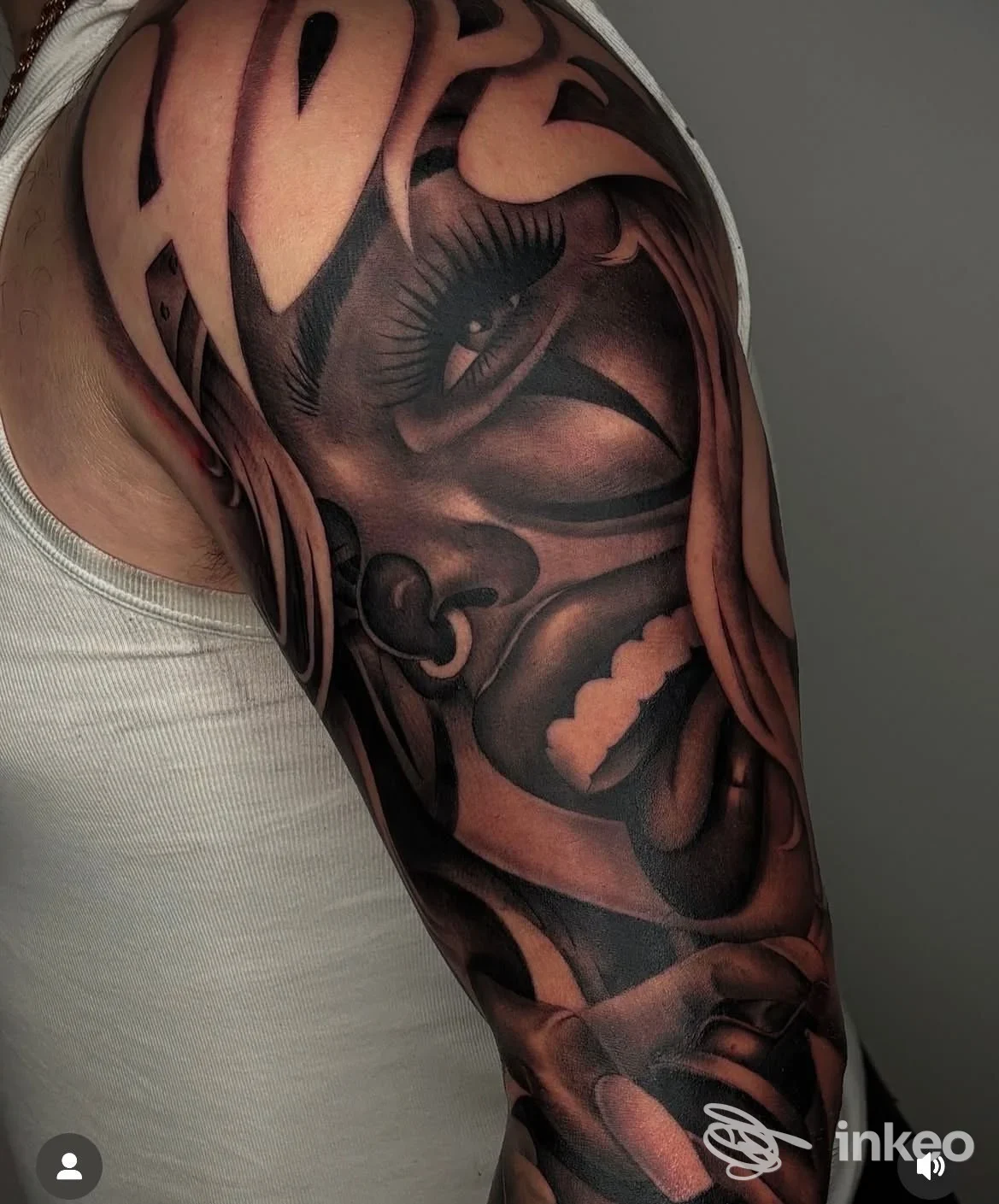 Tatuaggio a manica sul braccio e spalla realizzato da Tattoolook, Torino, con ritratto stilizzato in bianco e nero.