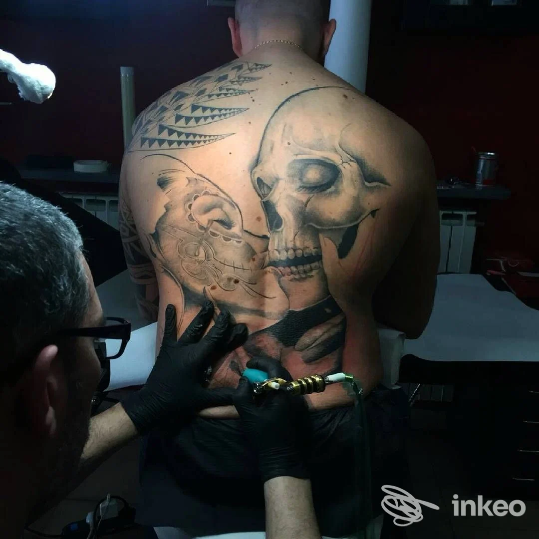 Tatuaggio realistico a tutta schiena in fase di esecuzione presso Three Bees Tattoo a Venaria Reale, artista al lavoro sulla zona lombare.