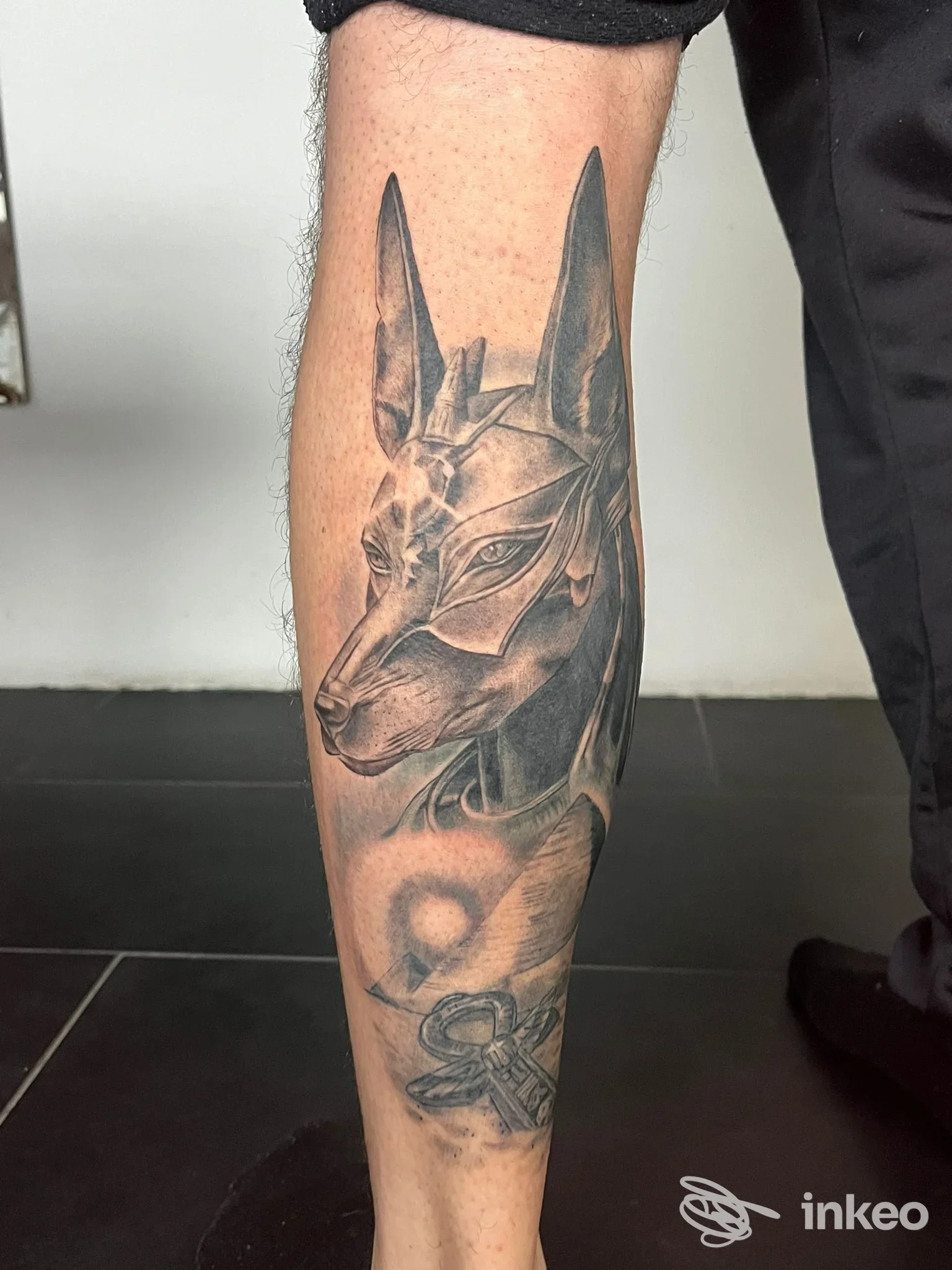 Tatuaggio realistico a inchiostro nero su polpaccio eseguito da Twenty nine tattoo a Villar Focchiardo, dettaglio testa stilizzata di canide.