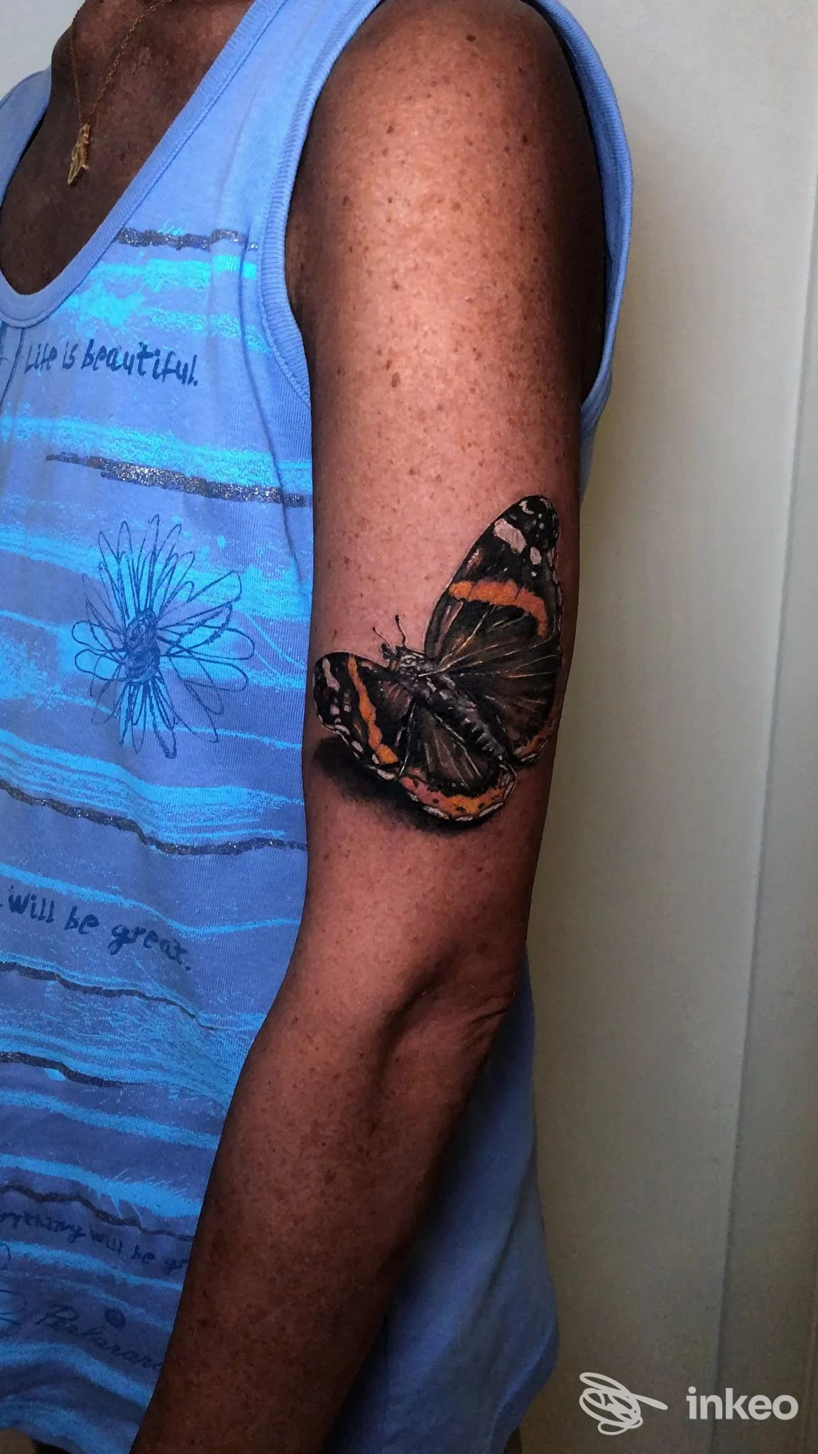 Grande tatuaggio realistico di una farfalla sul braccio superiore di una persona, fotografato in primo piano. Voodoo Ink Tattoo Shop - Tatuaggi Chieri, Chieri.