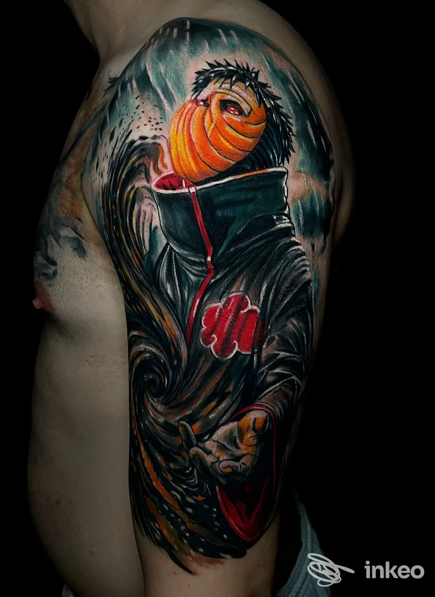 Tatuaggio a mezza manica su spalla e braccio con figura mascherata e forti contrasti cromatici, Voodoo Ink Tattoo Shop, Chieri.