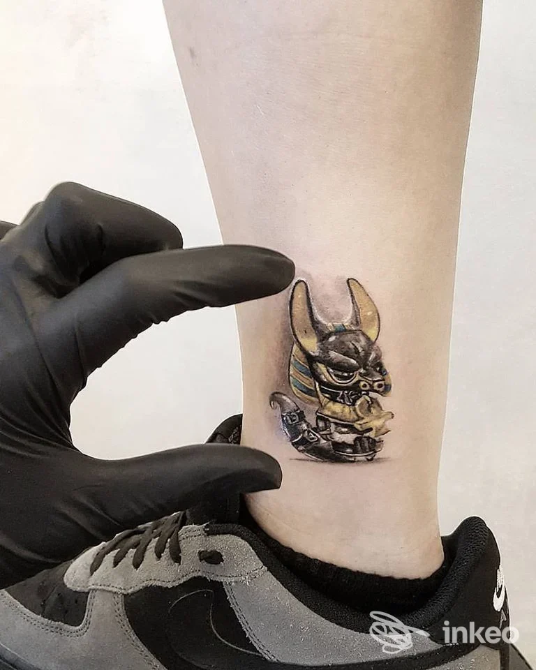 Tatuaggio Anubi colorato sulla caviglia mostrato da Voodoo Ink Tattoo Shop, Chieri.