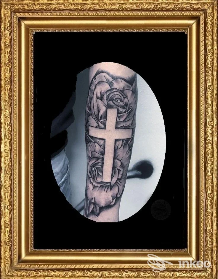 Tatuaggio su avambraccio con grande croce centrale e rose in bianco/nero, presentato dallo studio blues tattoo, Novara.