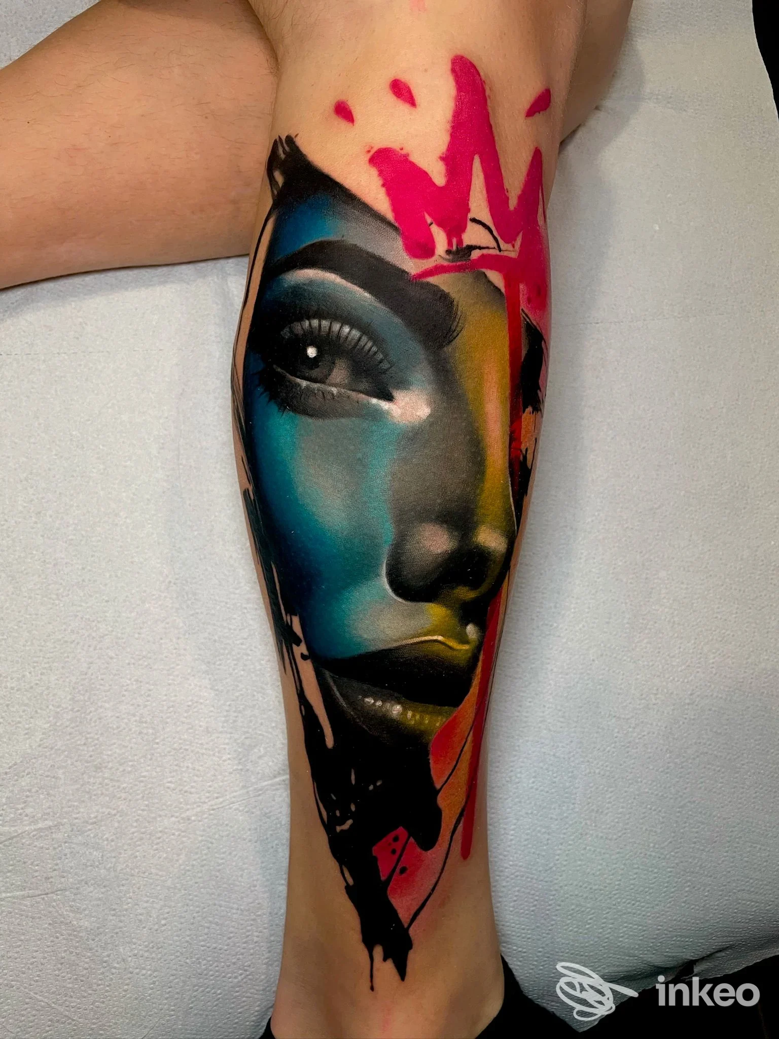 Grande tatuaggio colorato di volto stilizzato sul polpaccio, foto fornita da Taxi Tattoo Store, Torino.
