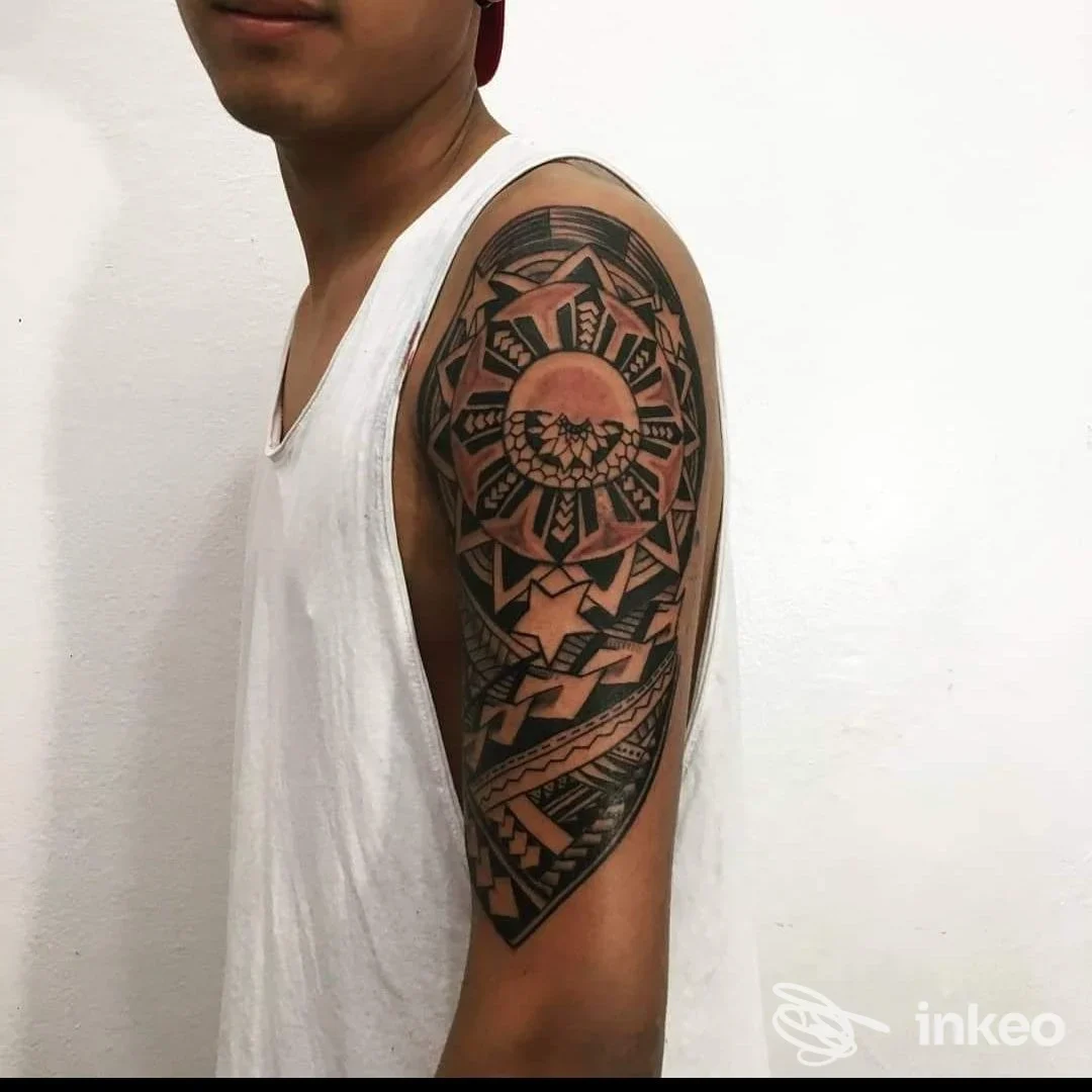 Tattoo geometrico a mandala sul braccio superiore destro di una persona, in stile blackwork, senza volto visibile; maglietta bianca senza maniche, studio Dynamic Milan.