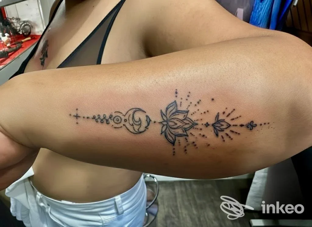 Braccio sinistro con tatuaggio ornamentale lineare, elementi decorativi e floreali lungo la parte alta, visibile senza volto, in ambiente studio Dynamic Milan.