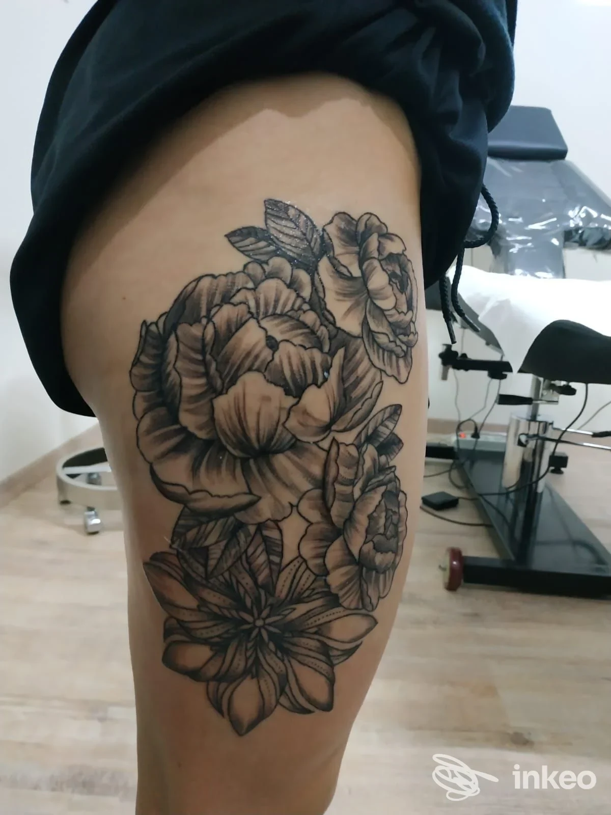 Tatuaggio floreale in bianco e nero sulla coscia, foto dallo studio Roby Tattoo a Gioia del Colle.