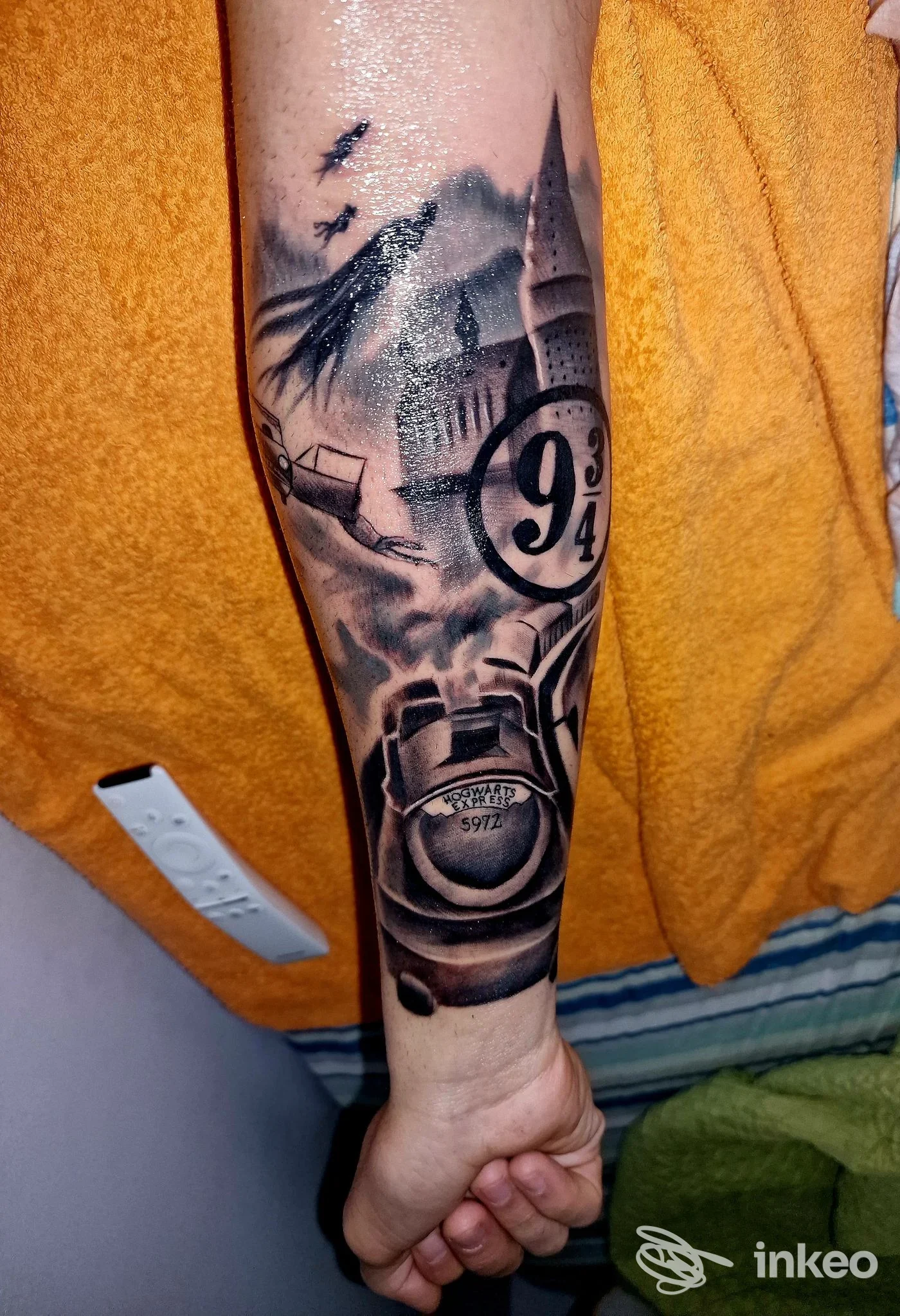 Tatuaggio realistico in bianco e nero sull'avambraccio con simbolo 9¾ e dettagli architettonici. Sacred Tattoo Bari, Bari.