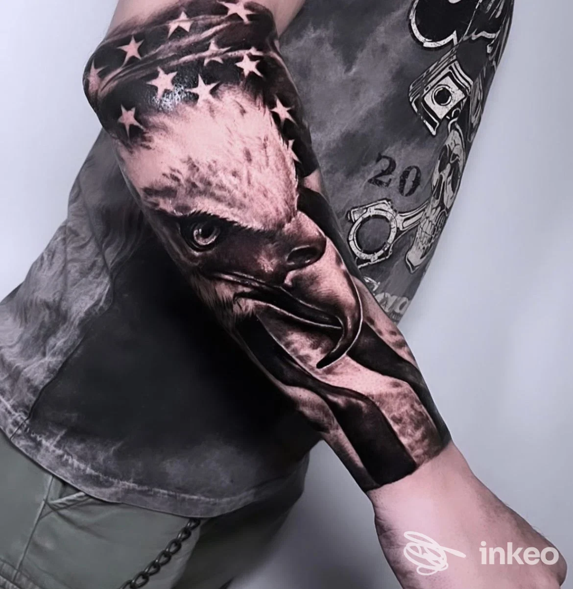 Tatuaggio realistico di aquila con elementi di bandiera sull'avambraccio, opera di Saverio Schingaro Tattoo Shop a Bari, in primo piano.