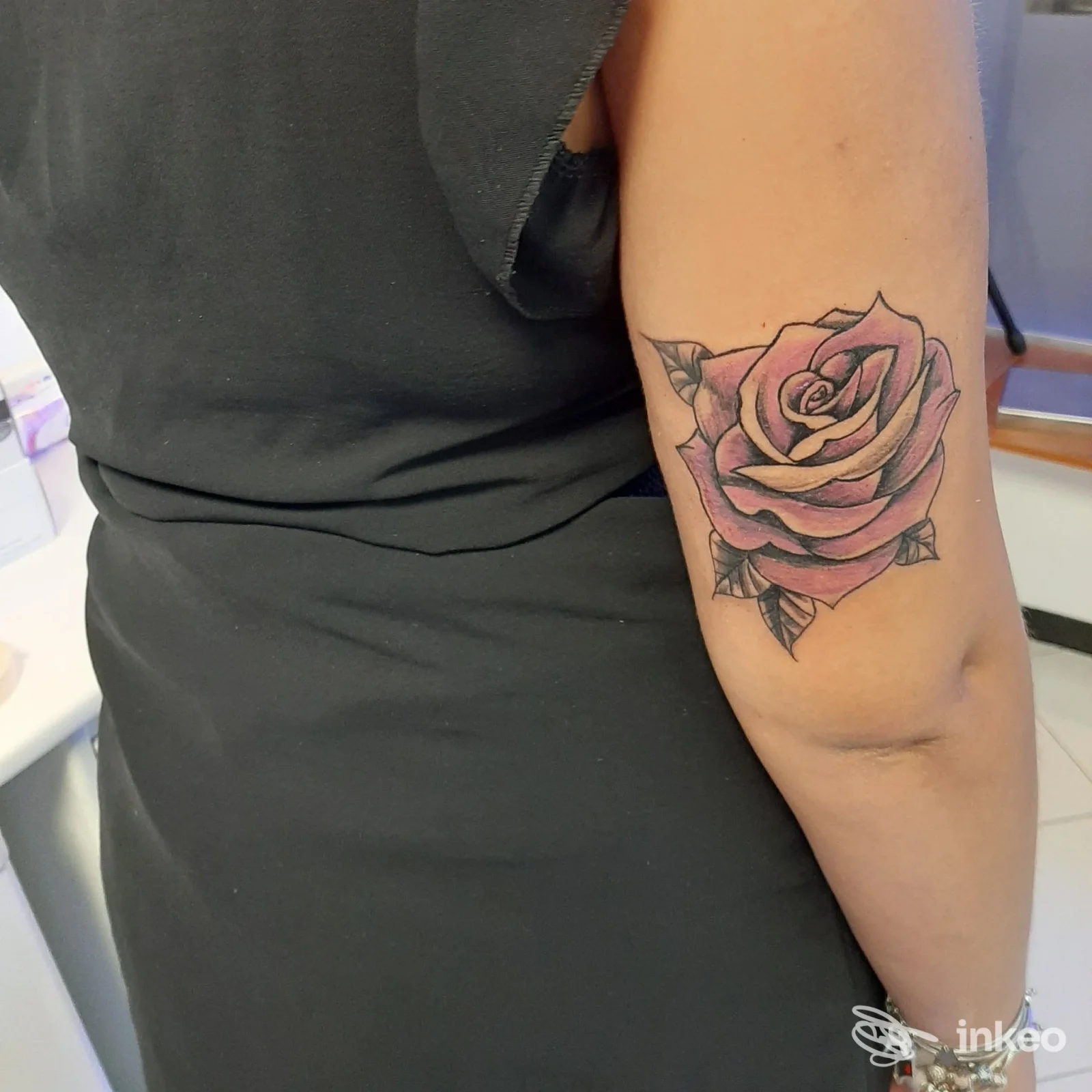 Tatuaggio a forma di rosa colorata sul braccio superiore realizzato da Radici Tribali tattoo piercing ad Andria.
