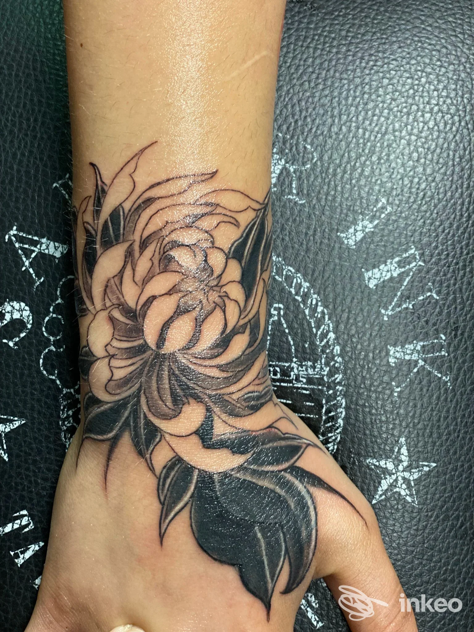 Tatuaggio floreale in nero sul polso e dorso della mano, foto dello studio Sailor Ink Tattoo a Brindisi.