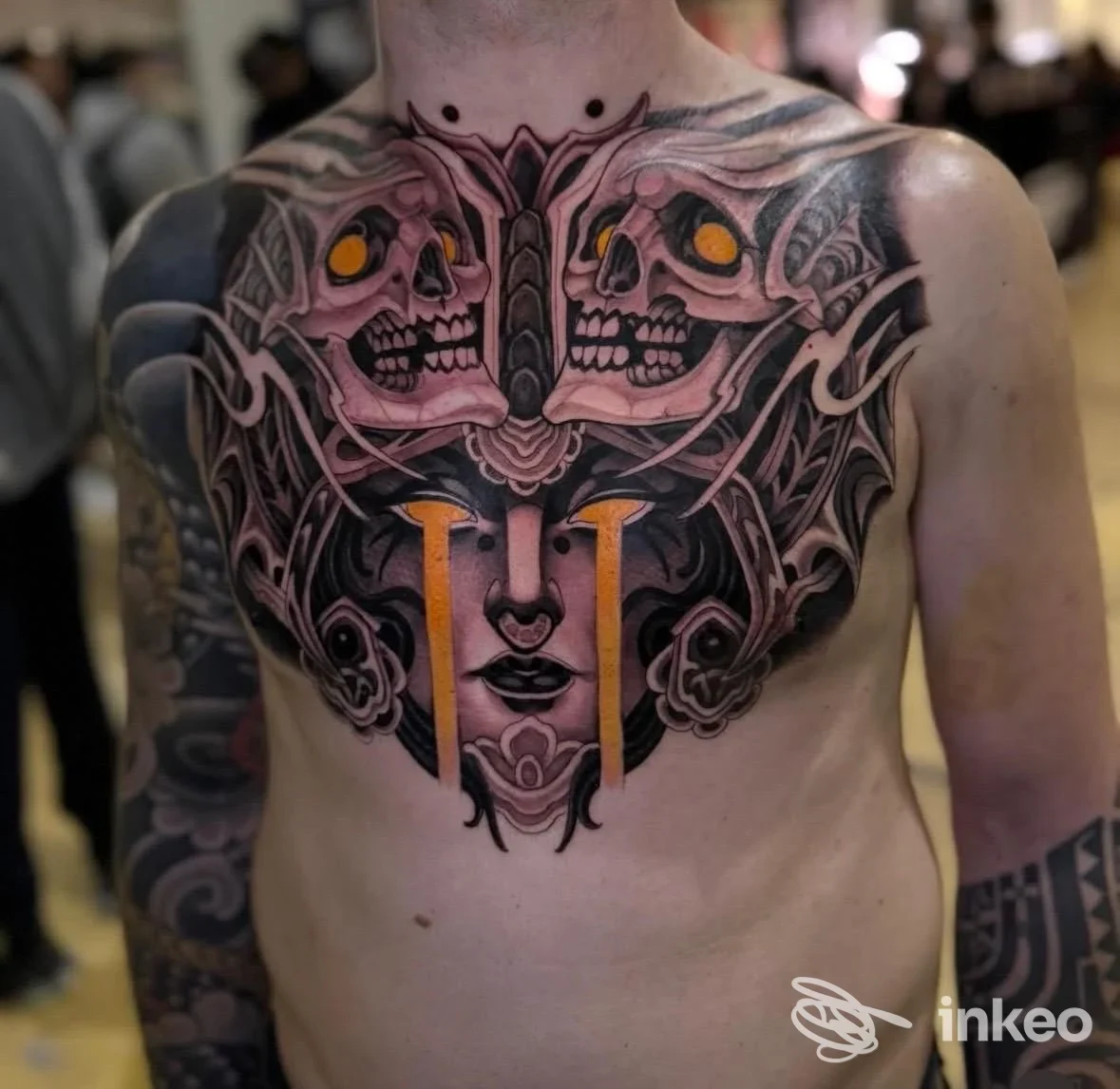 Grande tatuaggio frontale sul petto fotografato al Southside Tattoo Shop a Lecce, con motivi simmetrici neri e arancio.