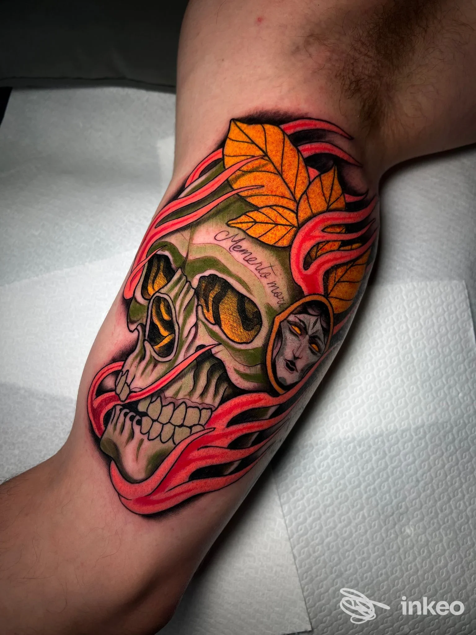 Tatuaggio su avambraccio con cranio stilizzato, foglie gialle e fiamme rosa: lavoro fotografato al Southside Tattoo Shop di Lecce.