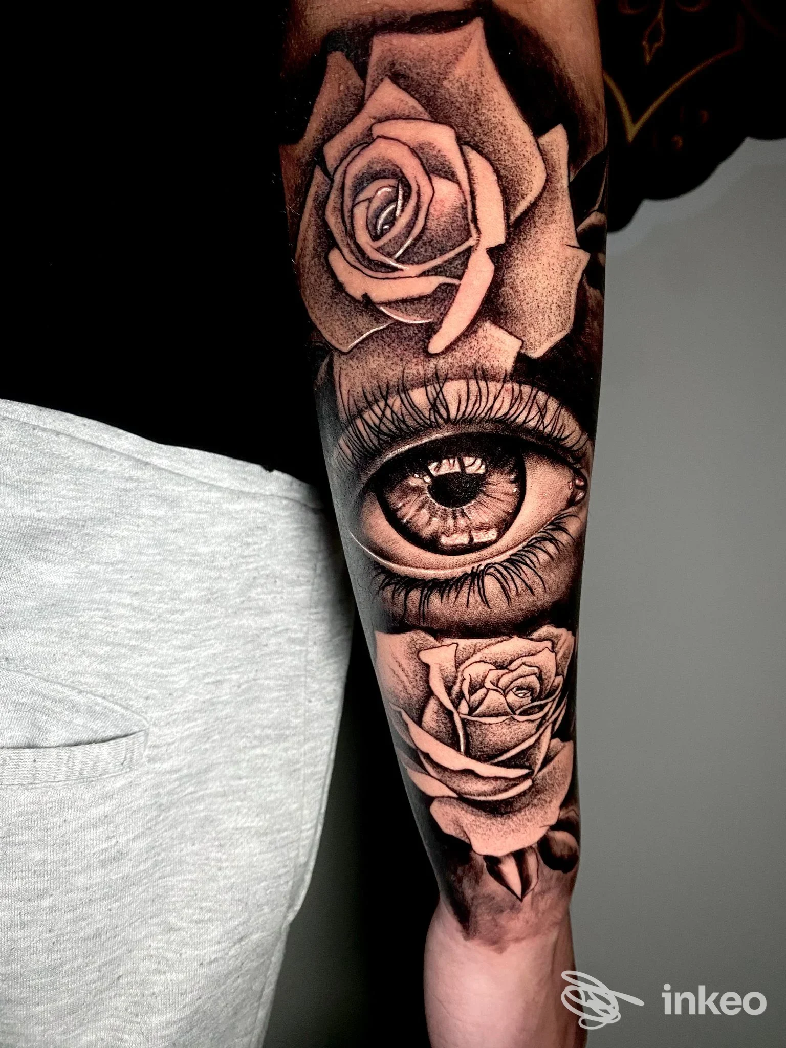 Tatuaggio realistico su avambraccio con occhio centrale e due rose, Spaccio Tattoo, Triggiano.