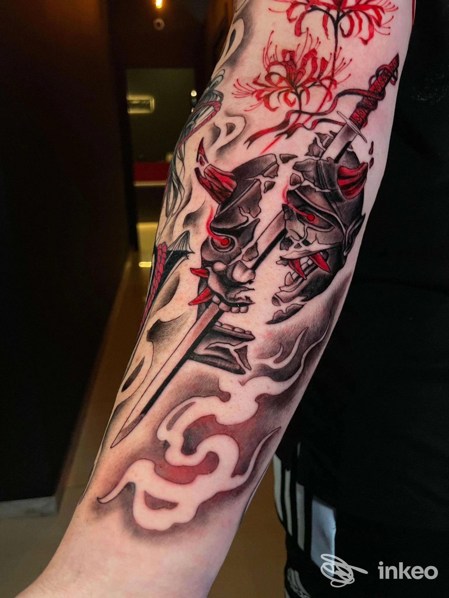 Tatuaggio su avambraccio con maschere e pugnale, colori nero e rosso — SMEK Tattoo, Gallipoli.