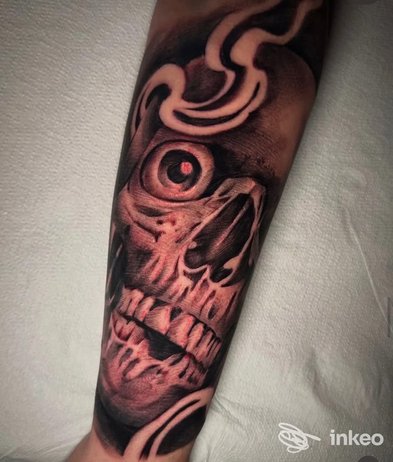 Tatuaggio realistico black & grey di un teschio con occhio rossastro sull'avambraccio, fotografia del lavoro di Squiggle Tattoo Studio, Capurso.