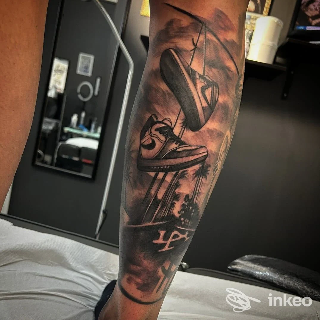 Tatuaggio realistico di un paio di sneaker appese sull'avambraccio, foto scattata nello Squiggle Tattoo Studio a Capurso.