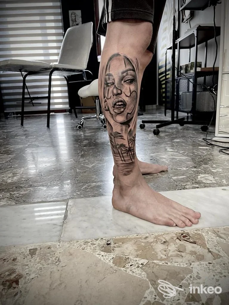 Fotografia del tatuaggio sul polpaccio realizzato da Tattoo Tankhamon a Torchiarolo, ritratto femminile stilizzato con palme.