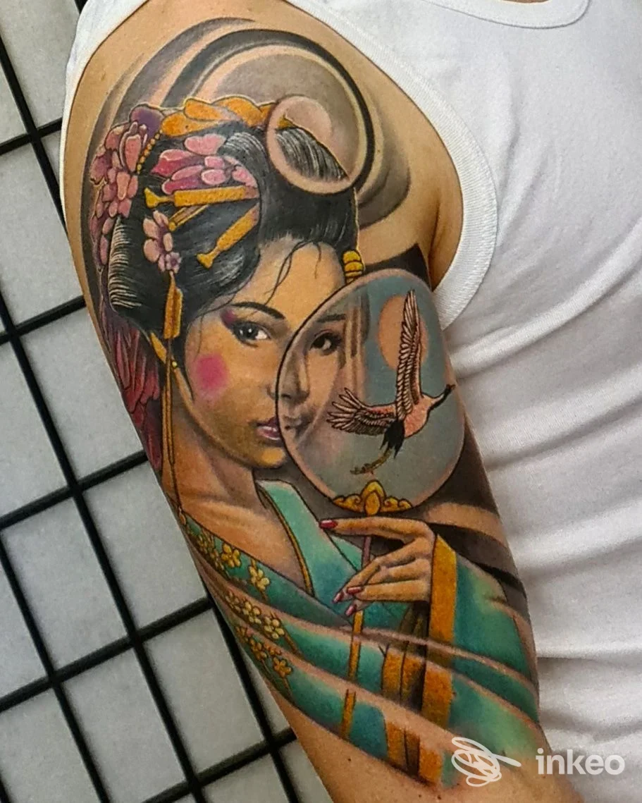 Tatuaggio a colori su braccio e spalla raffigurante una donna con ventaglio e dettagli floreali, realizzato da Skin Art Tattoo, Lecce.