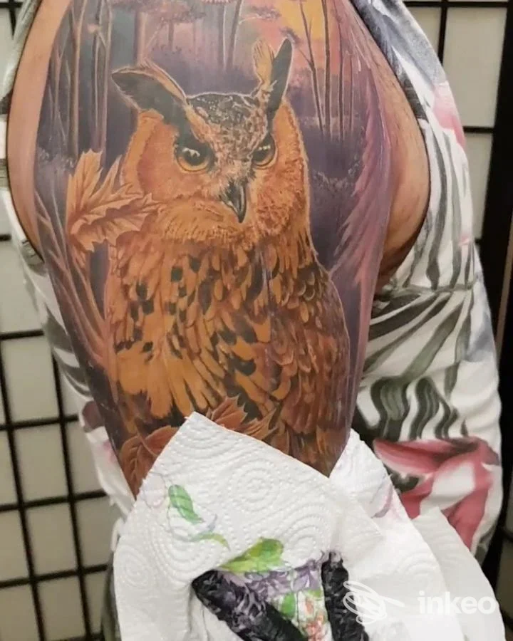 Tatuaggio realistico di un gufo sul braccio superiore, realizzato da Skin Art Tattoo a Lecce.