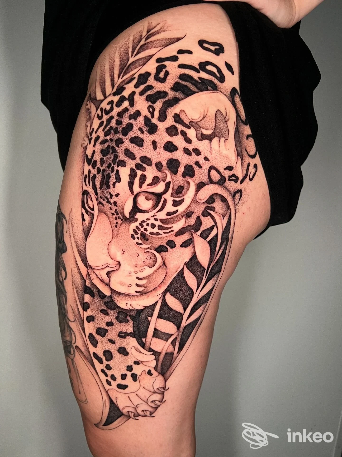 Tatuaggio su coscia con grande giaguaro stilizzato e volto femminile, The Black Tattoo, Putignano.