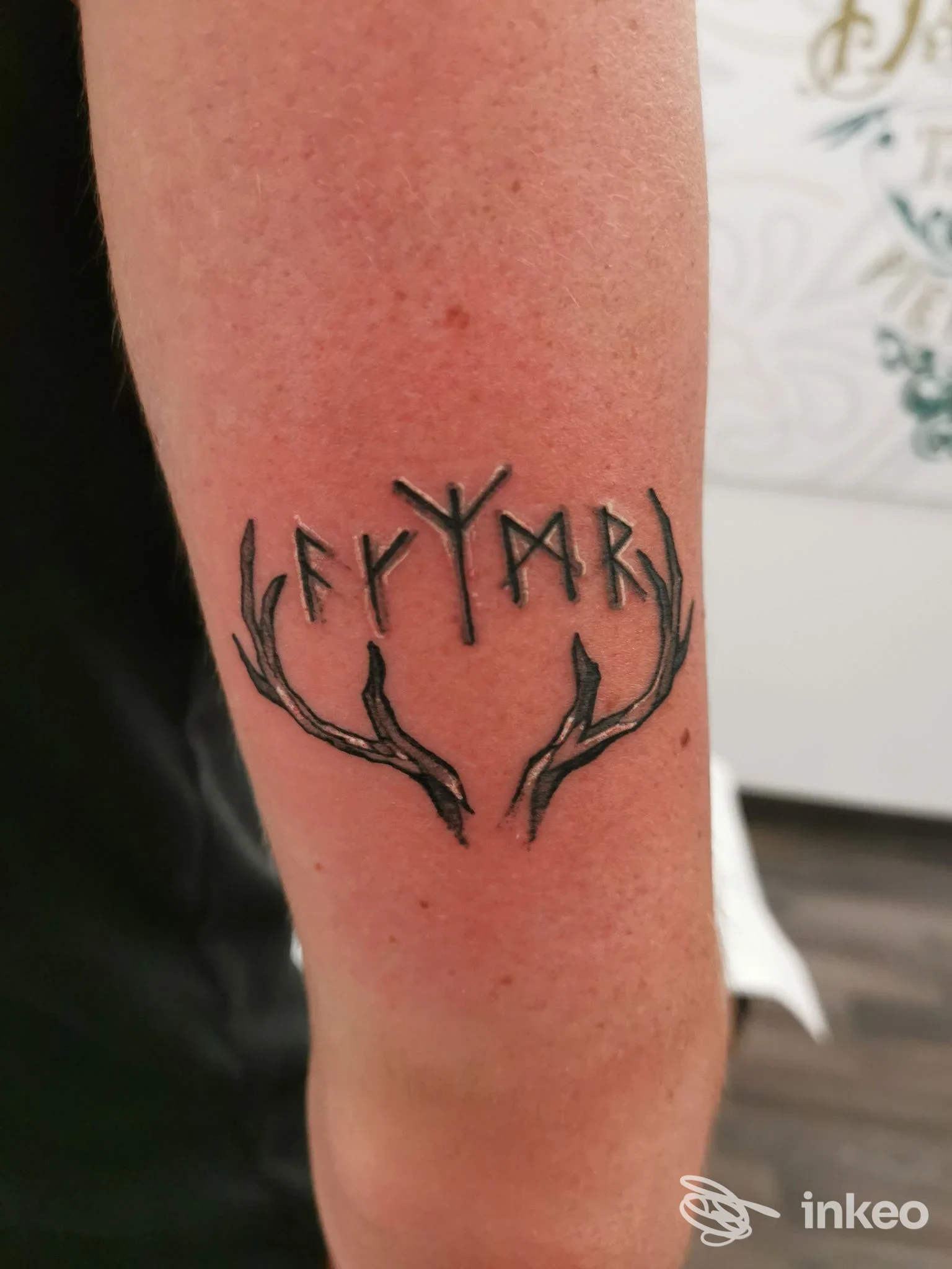 Tatuaggio nero con corna stilizzate e simboli runici sull'avambraccio, realizzato da VOODOO TATTOO STUDIO a Ruffano.