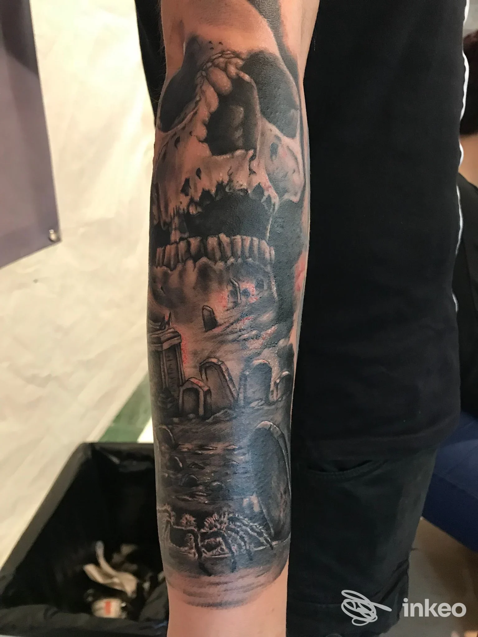 Avambraccio tatuato con grande teschio e scena di cimitero, foto inviata dallo studio Vale's Tattoo a Lizzano.