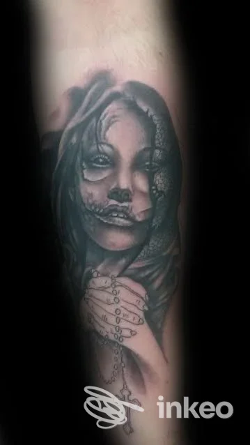 Dettaglio di tatuaggio realistico raffigurante volto femminile con mano e rosario sull'avambraccio, Vale's Tattoo Lizzano, Lizzano.