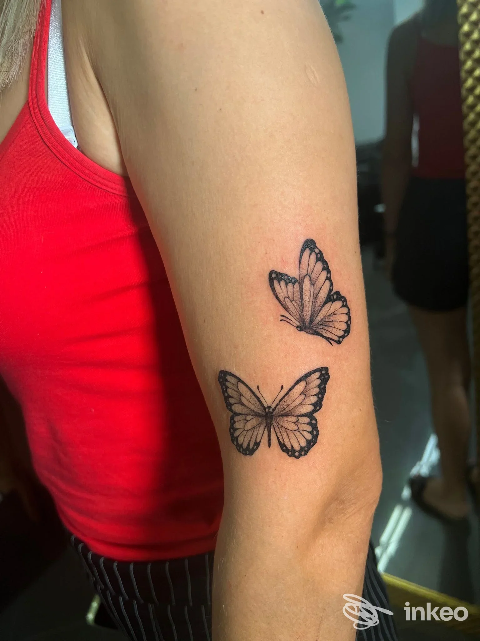 Due farfalle tatuate in nero sul braccio esterno; foto di Vegvisir Tattoo Studio, Ruvo di Puglia.