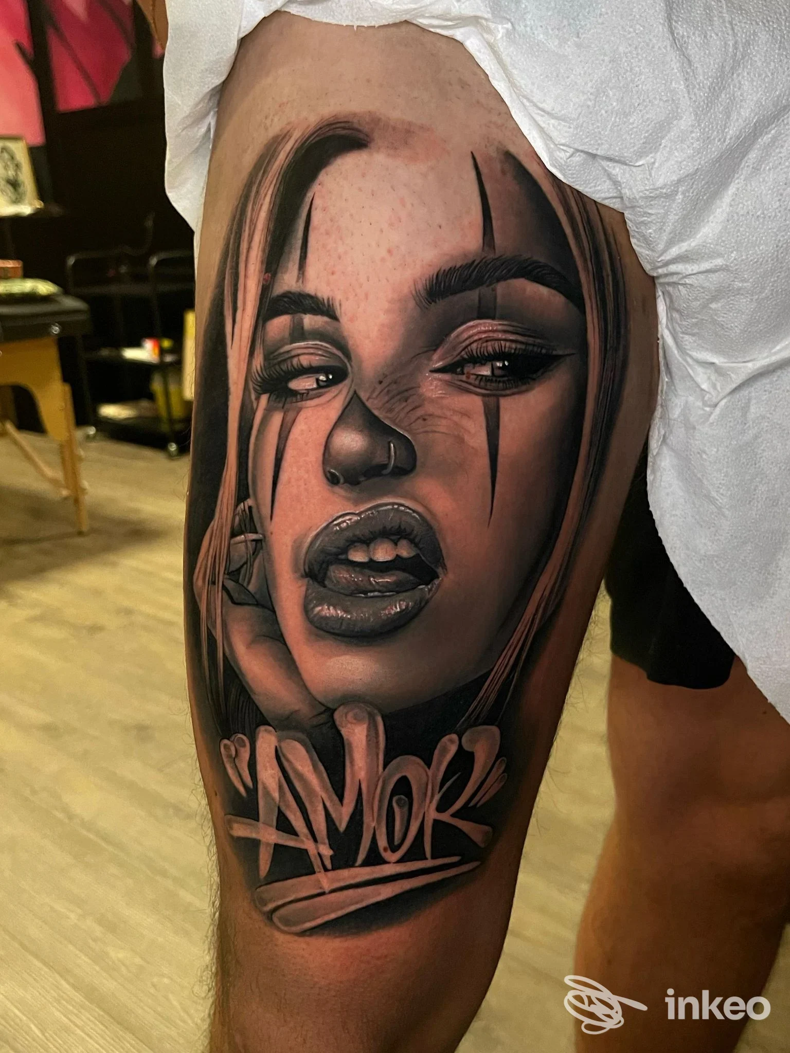 Tattoo realistico su polpaccio raffigurante testa femminile con linee drammatiche, ombre e una scritta stilizzata in bianco-nero, Studio Pink Parlour Tattoo a Cassano d'Adda.